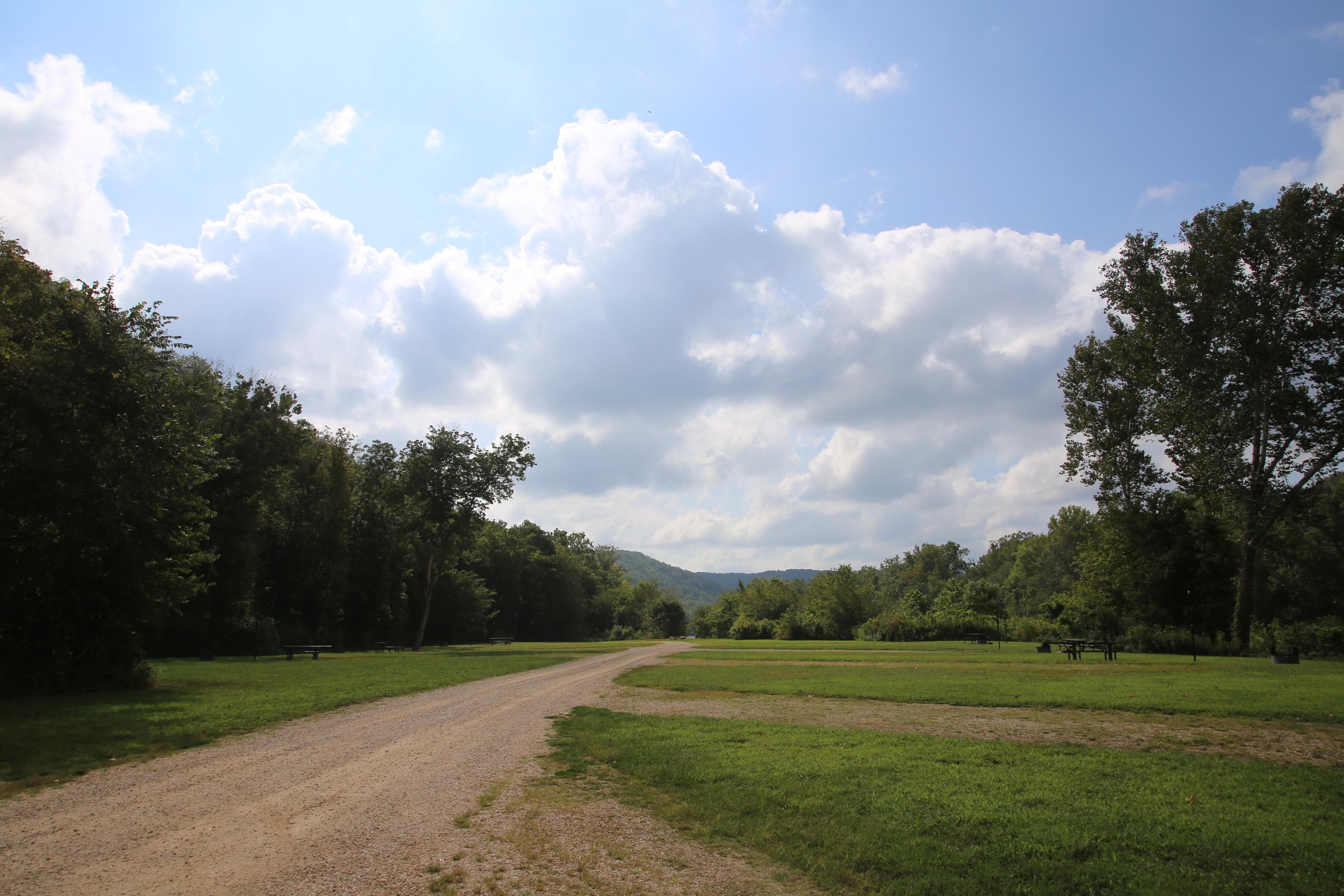 A grassy campground with a central gravel path.